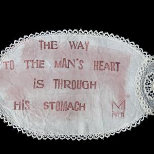 The way to the man's heart, 2022, Inchiostro e cera epilatoria su centrino da corredo, 31x19cm